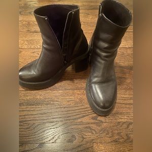 Men’s black leather boots with a big platform and heel.